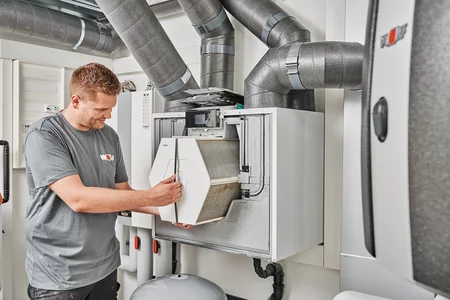 Monteur wechselt den Wärmetauscher einer Wohnraumlüftung
