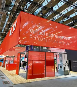 Roter Messestand von WOLF mit umlaufendem Deckenbanner in Signalfarbe