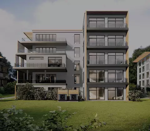 Vor einem Mehrfamilienhaus stehen zwei WOLF Luft/Wasser-Wärmepumpe als Kaskade