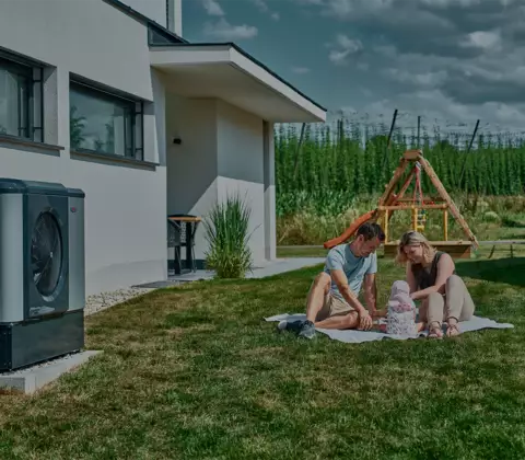Familie im Garten mit Wärmepumpe